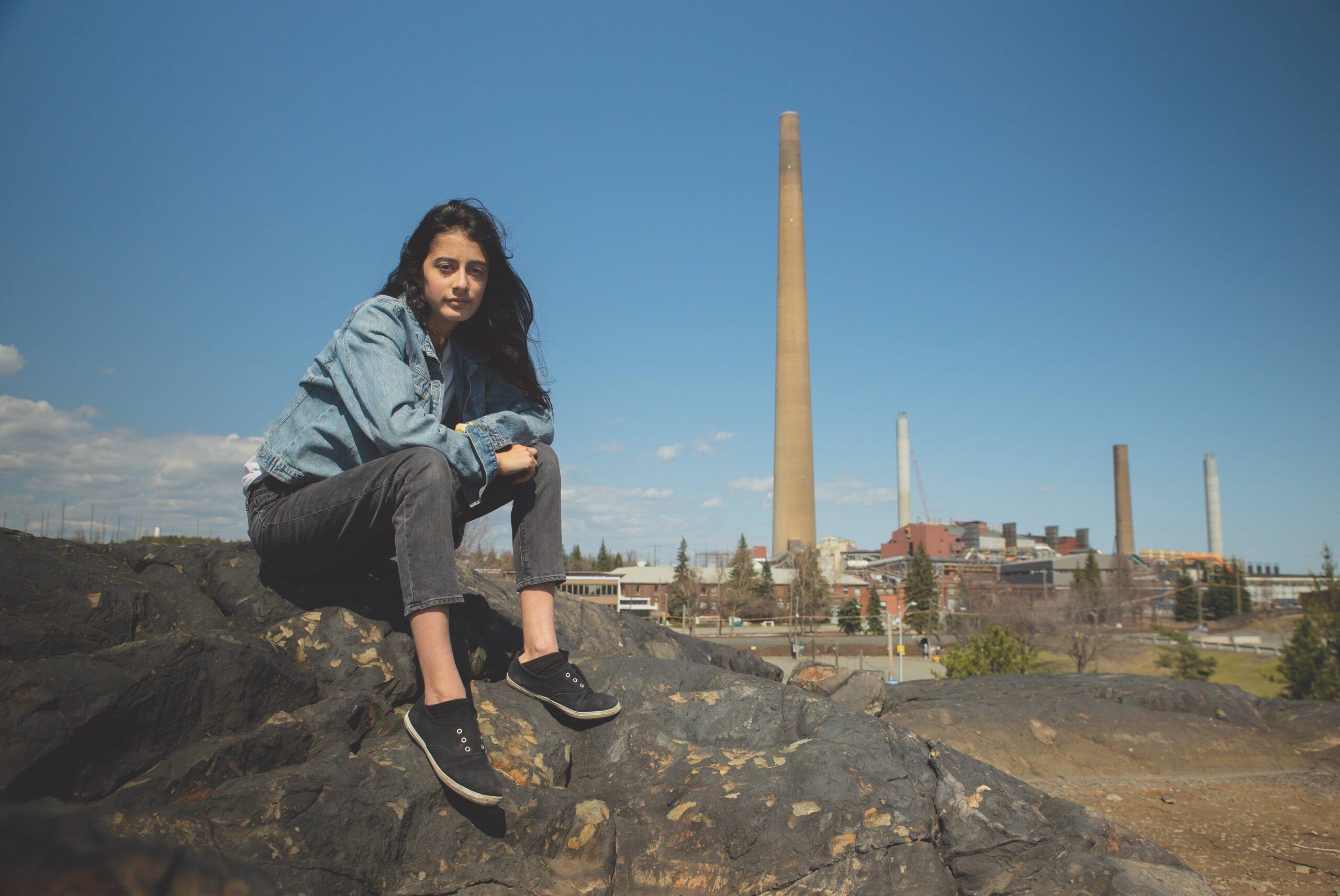 Youth Sophia Mather sits on a rock in Sudbury, Ontario.