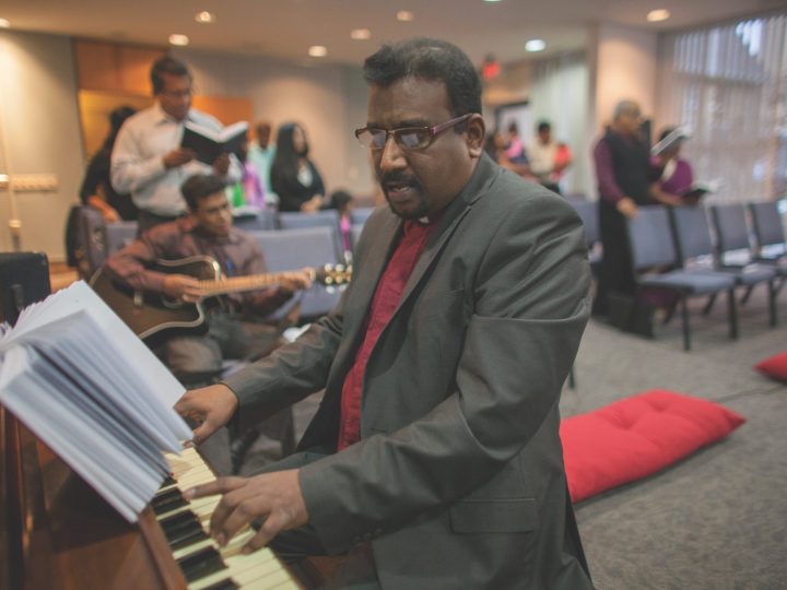 Standing man plays piano