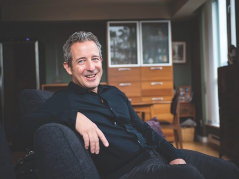 man reclined on couch looking at camera
