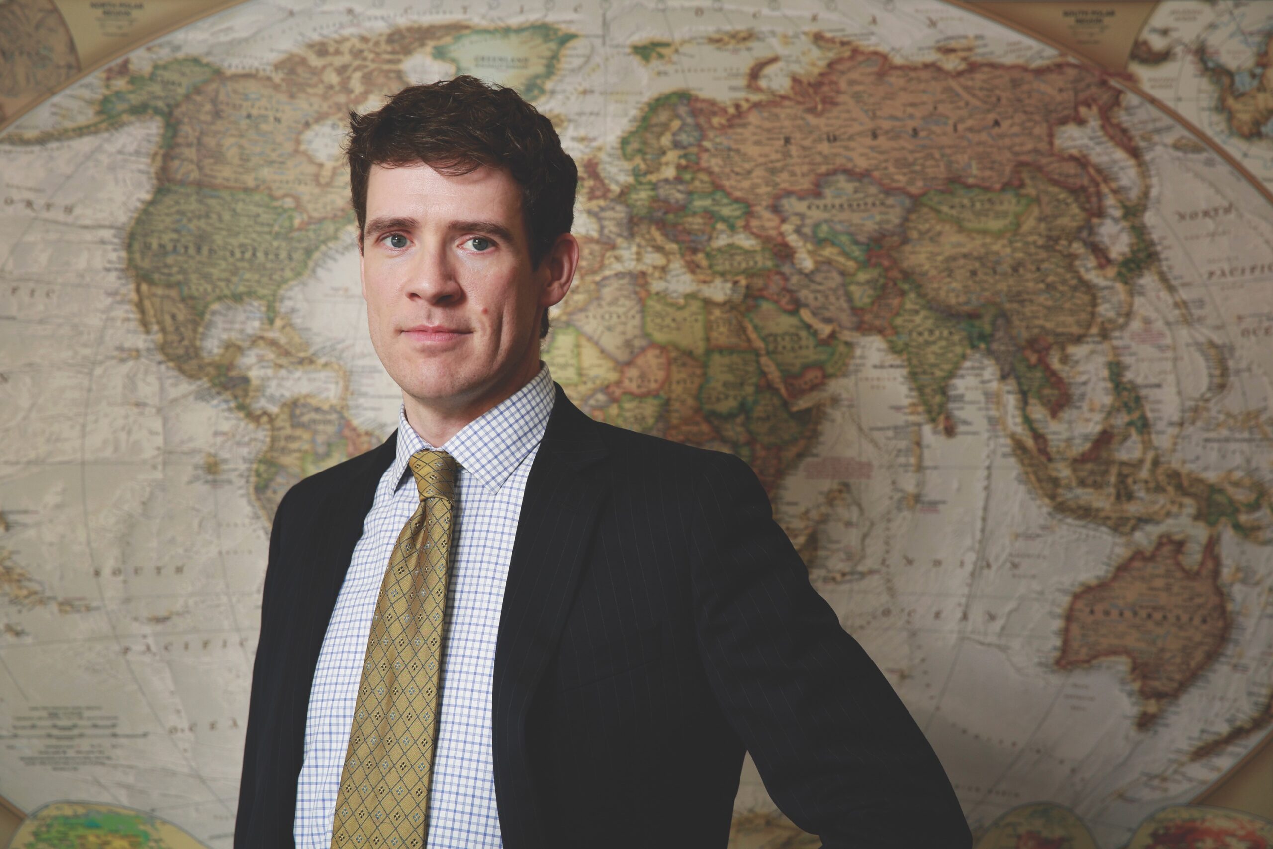 Man looking at camera in front of world map