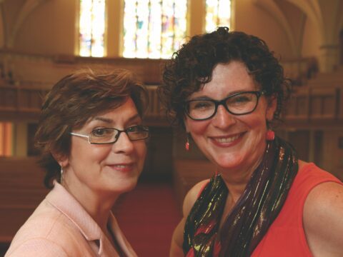 Two white women in church looking at camera
