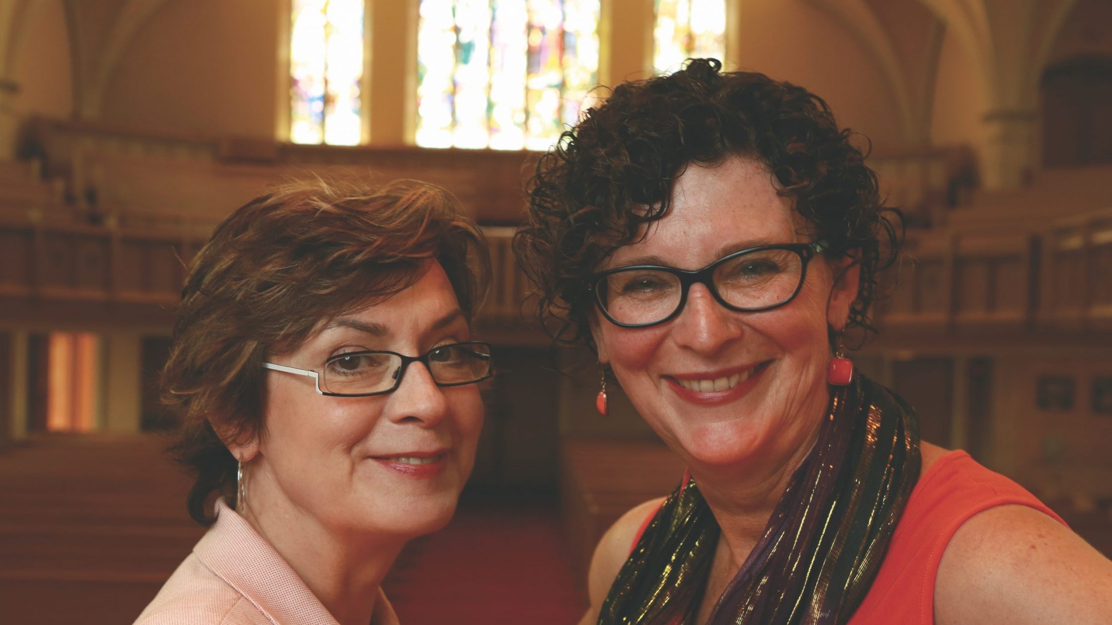 Two white women in church looking at camera