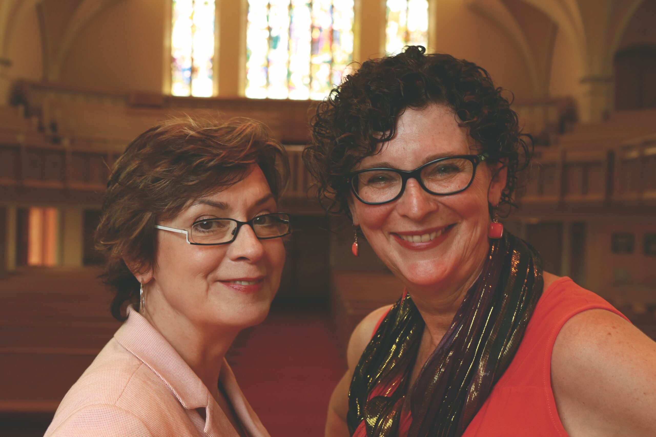 Two white women in church looking at camera