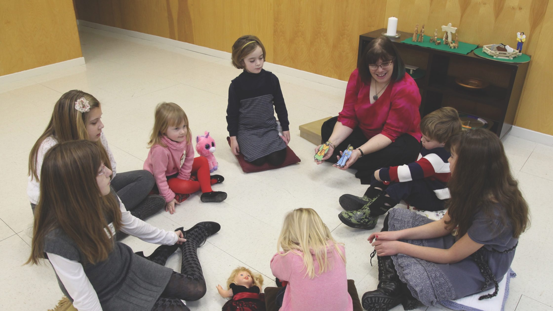 children sitting on floor in circle with teacher