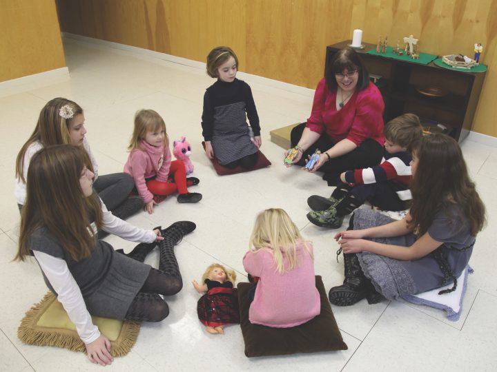 children sitting on floor in circle with teacher