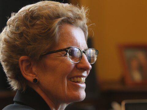 White woman with glasses in profile, smiling
