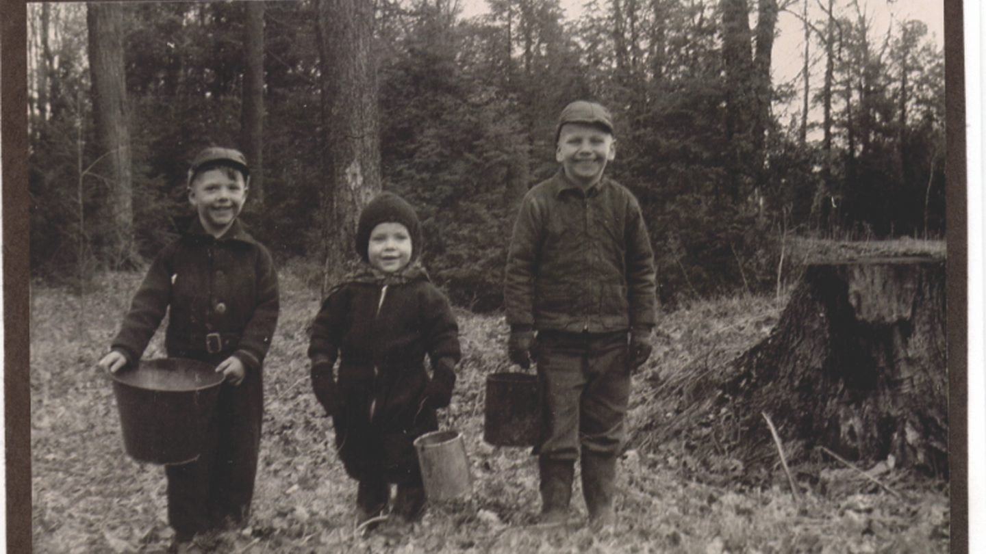 black and white shot of three children in woods
