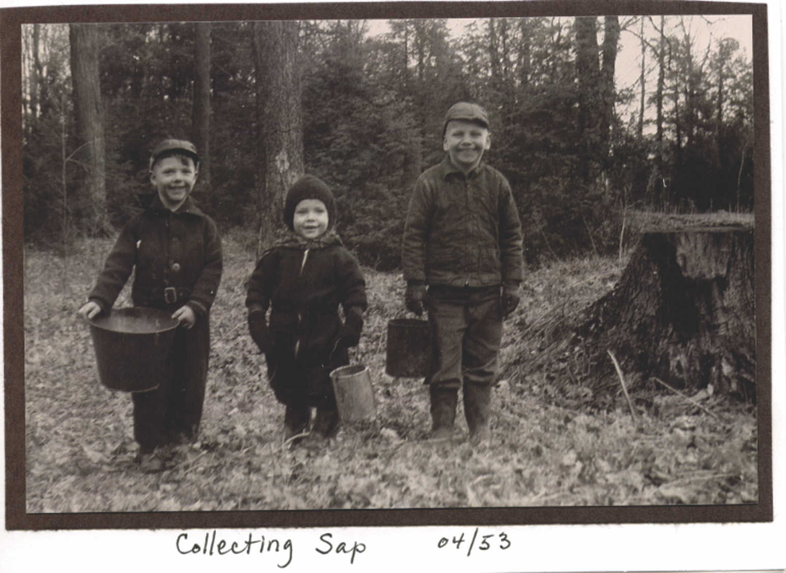 black and white shot of three children in woods