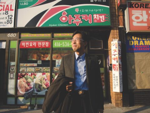 Korean man on street in front of Korean shops
