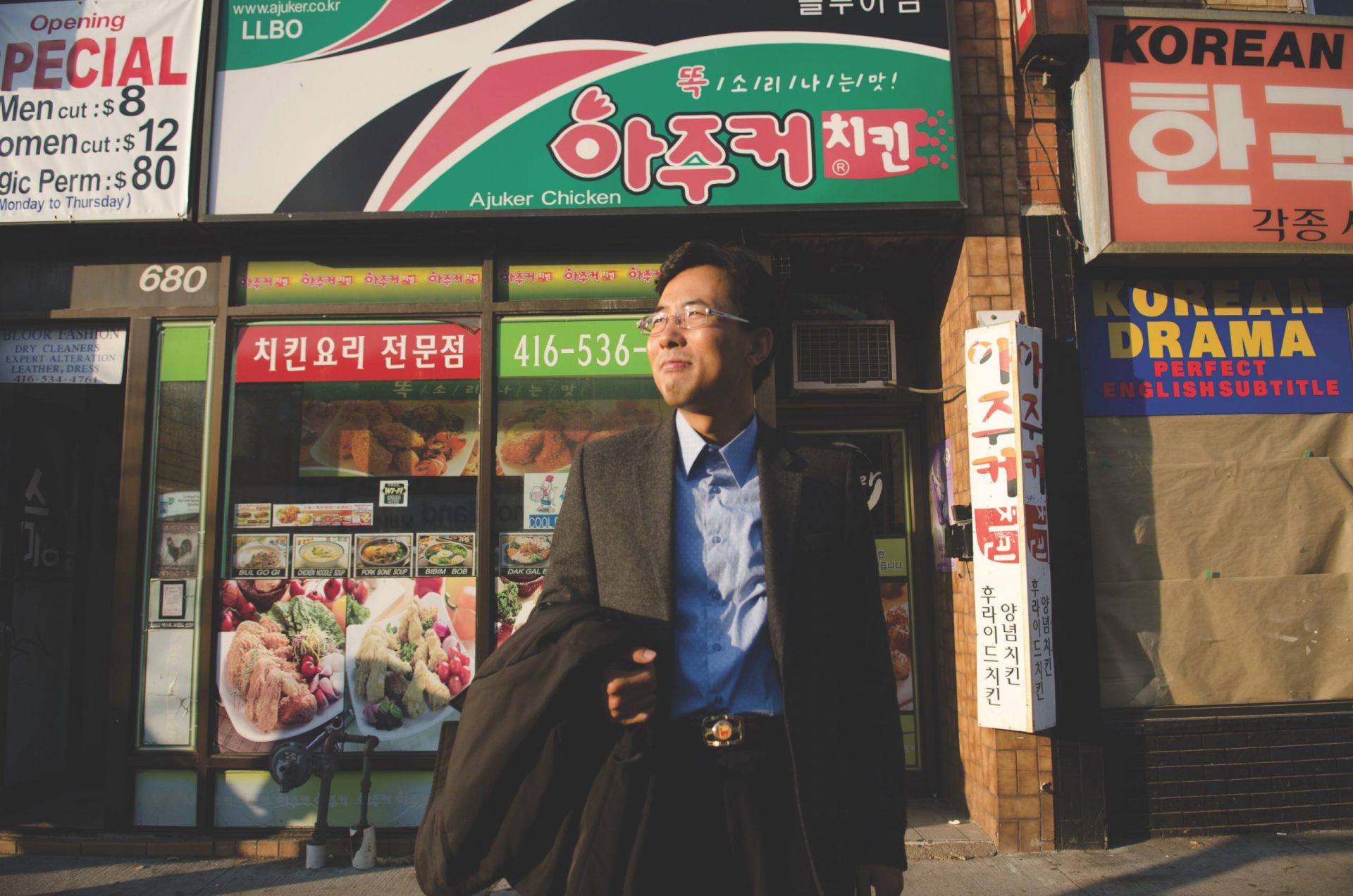 Korean man on street in front of Korean shops