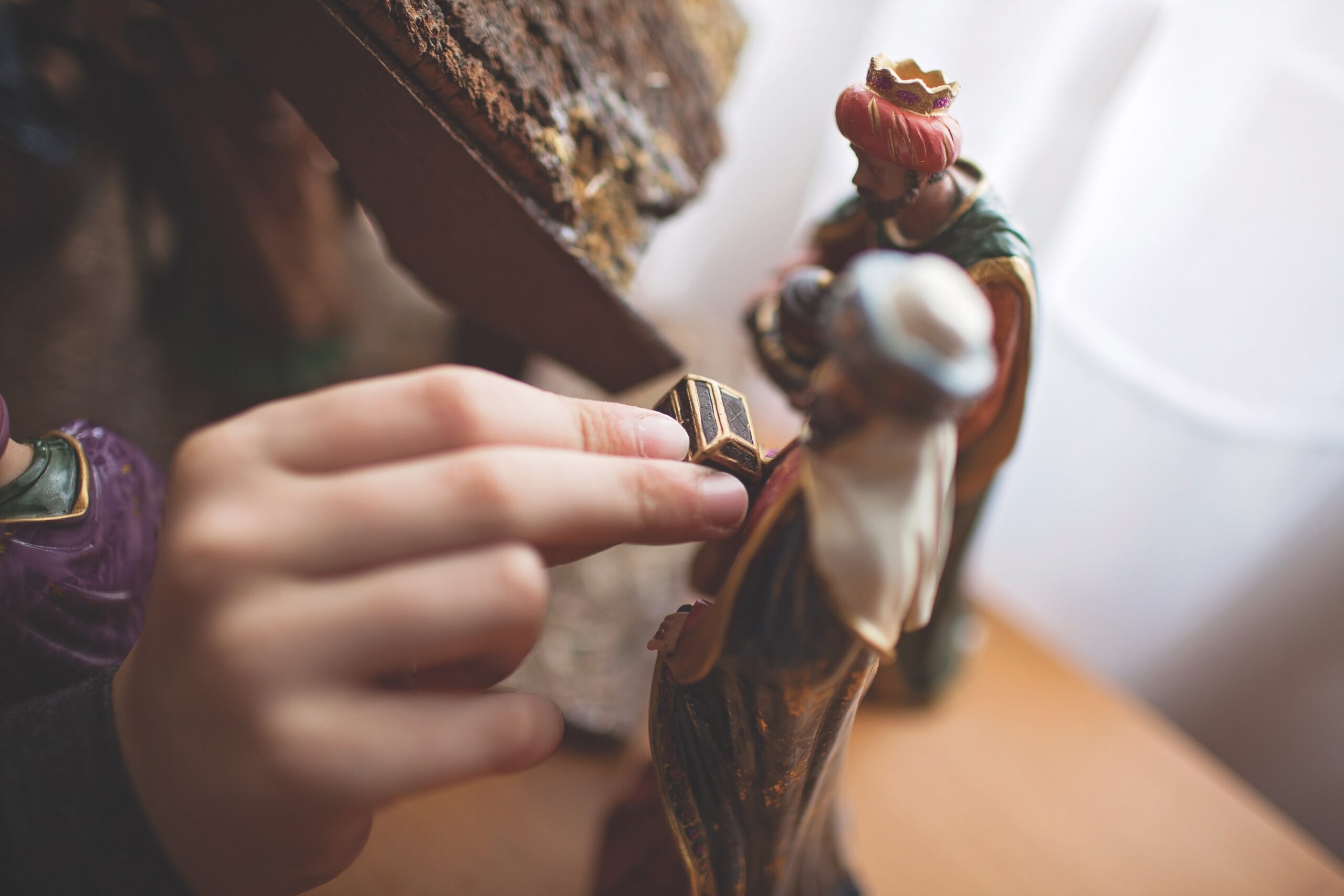 hand putting gift near crèche