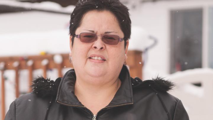 Indigenous woman in sunglasses and parka looking into camera