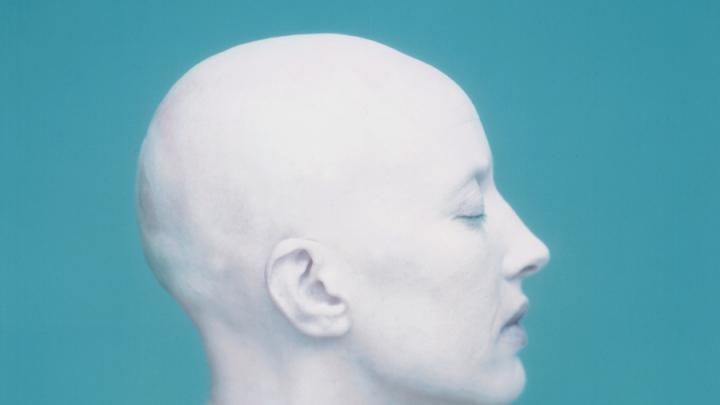 hairless white woman in profile against blue