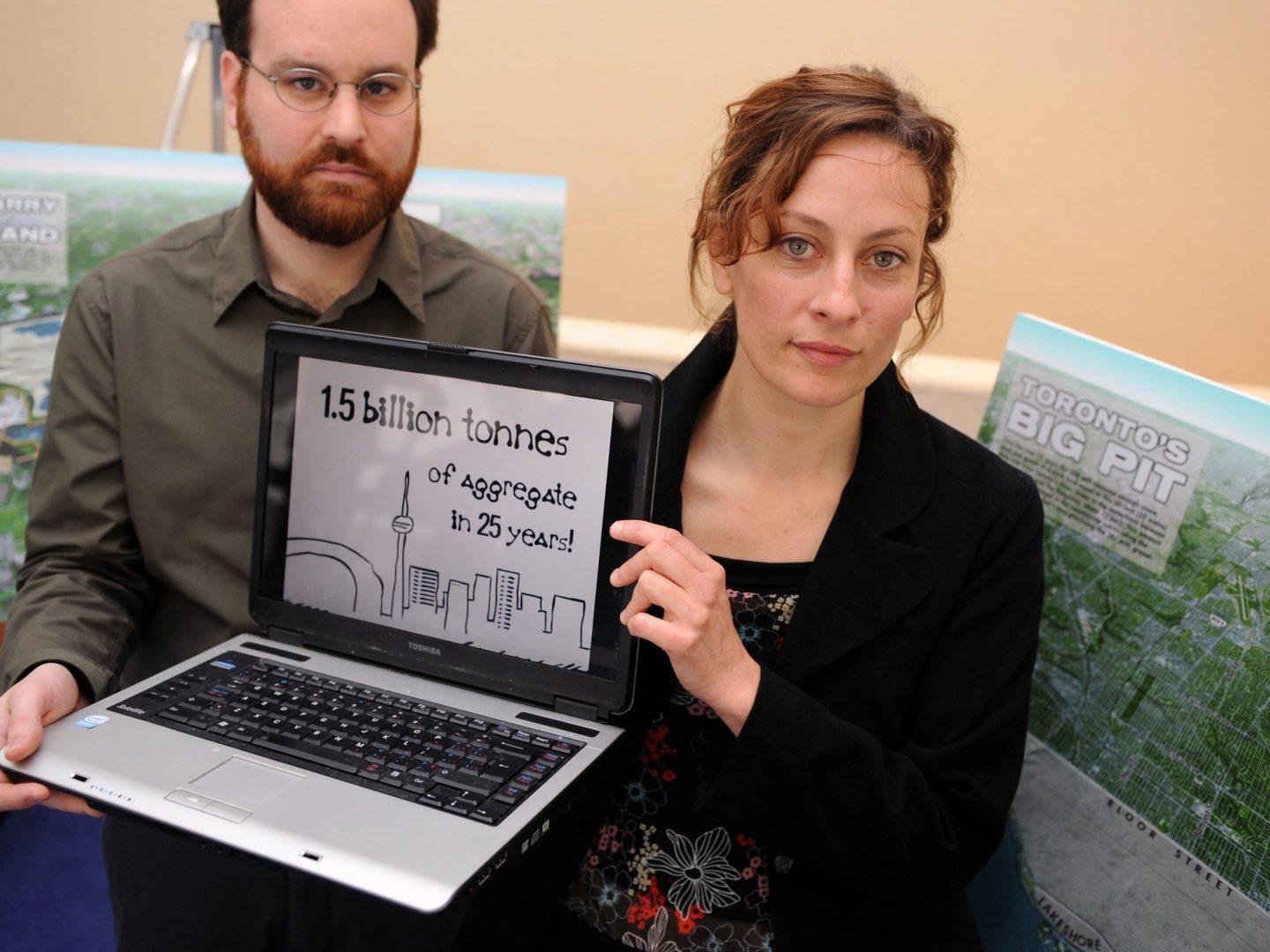 White woman and man holding computer