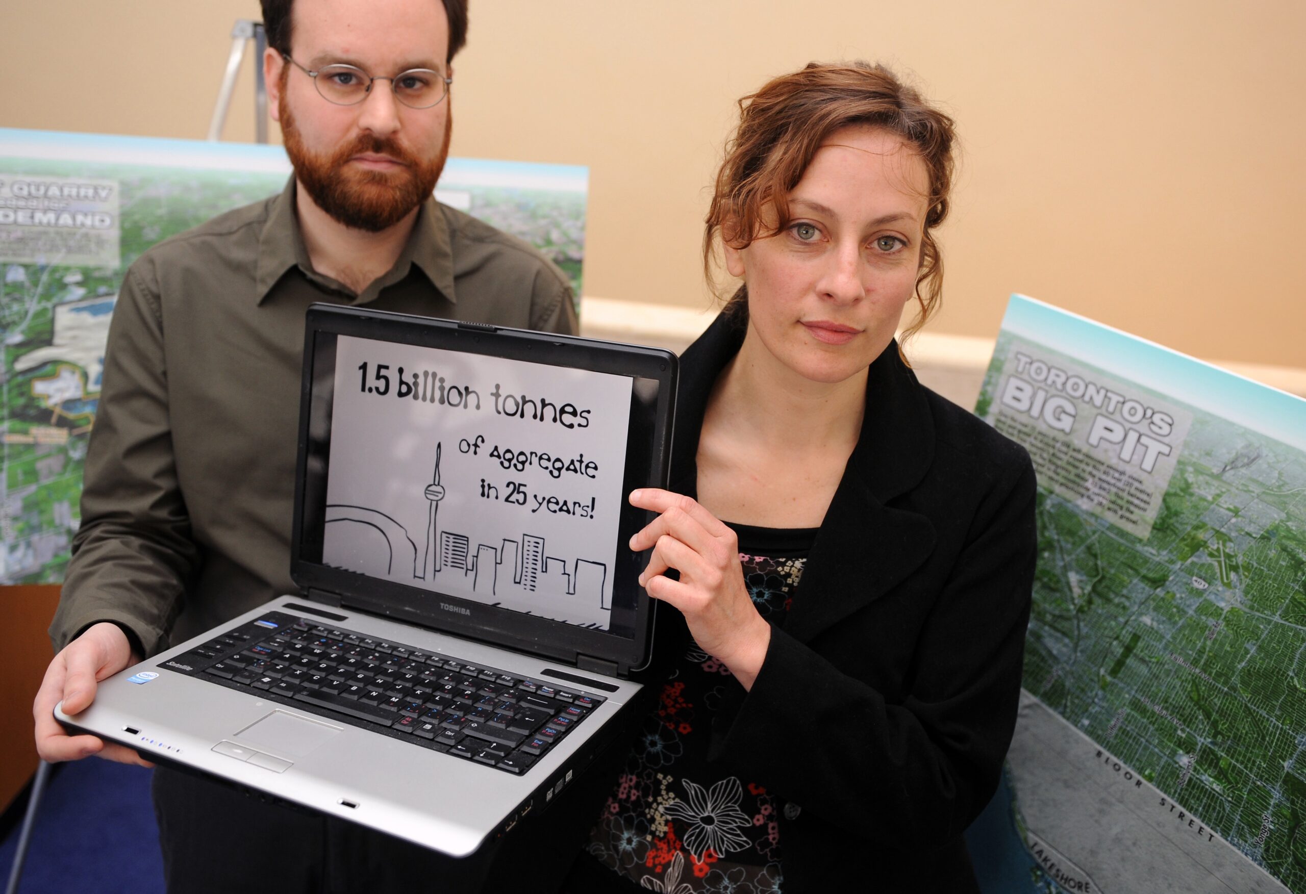 White woman and man holding computer
