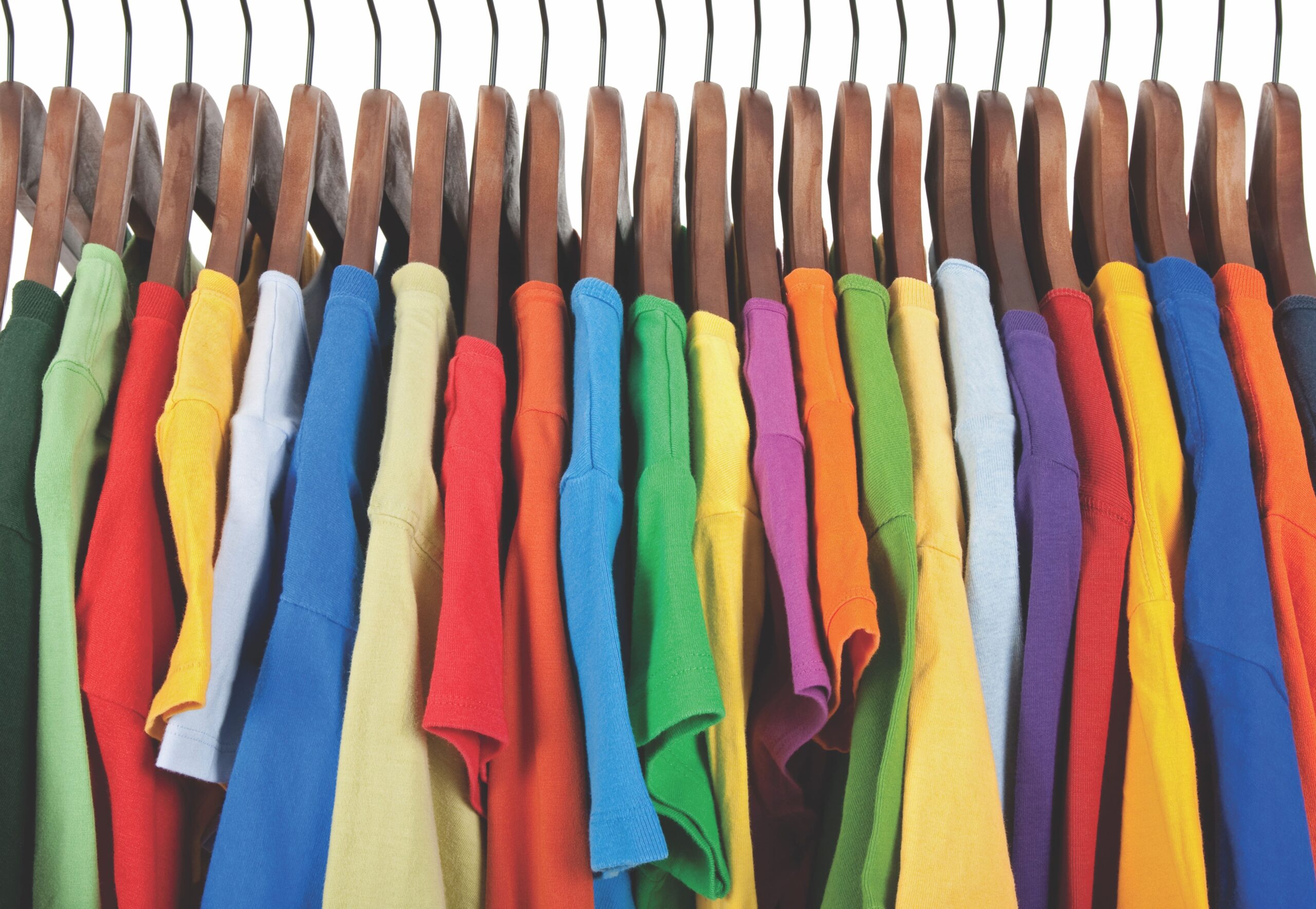 row of colourful T-shirts hanging on a rack