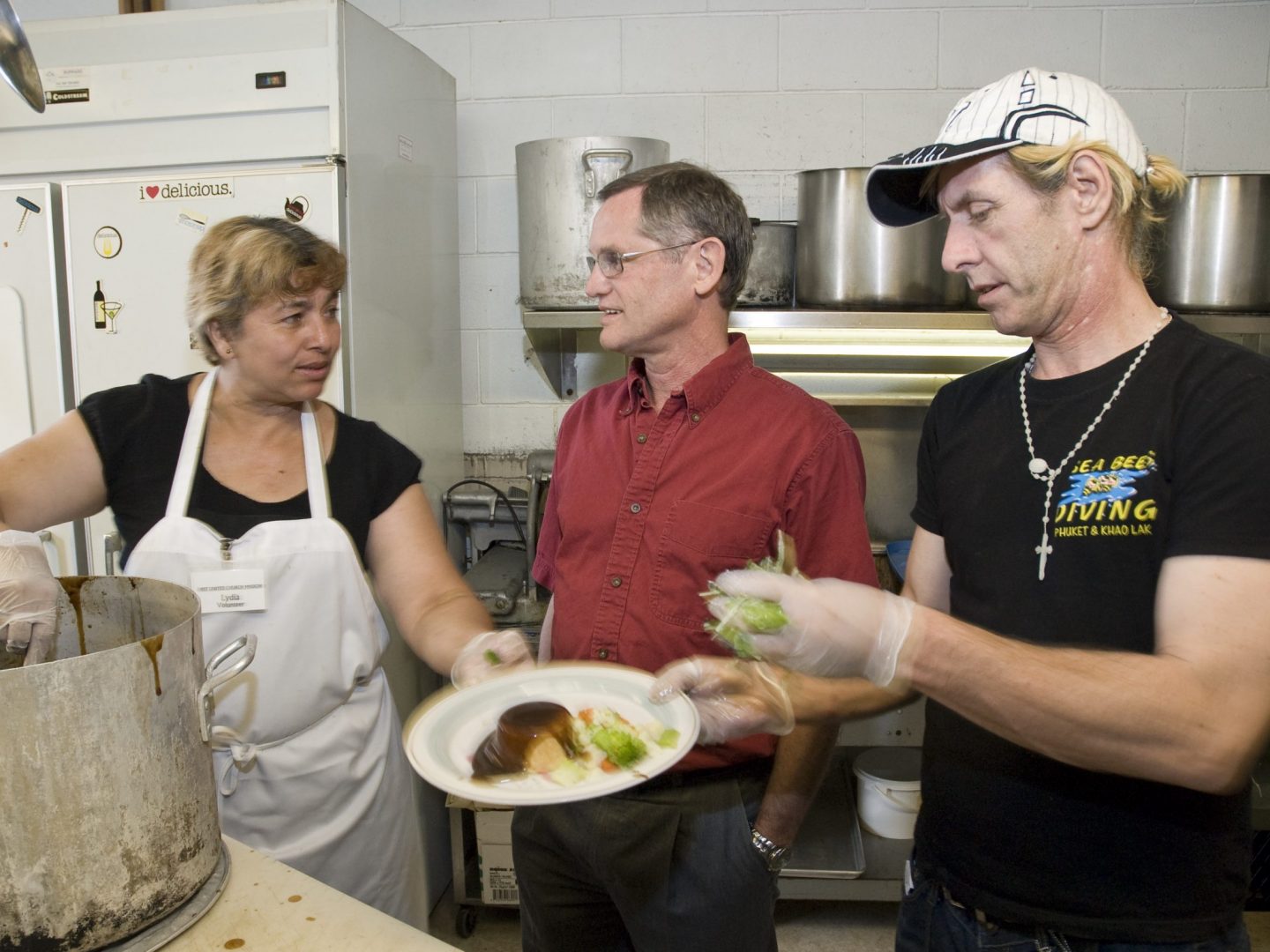 two white men and white woman in kitchen