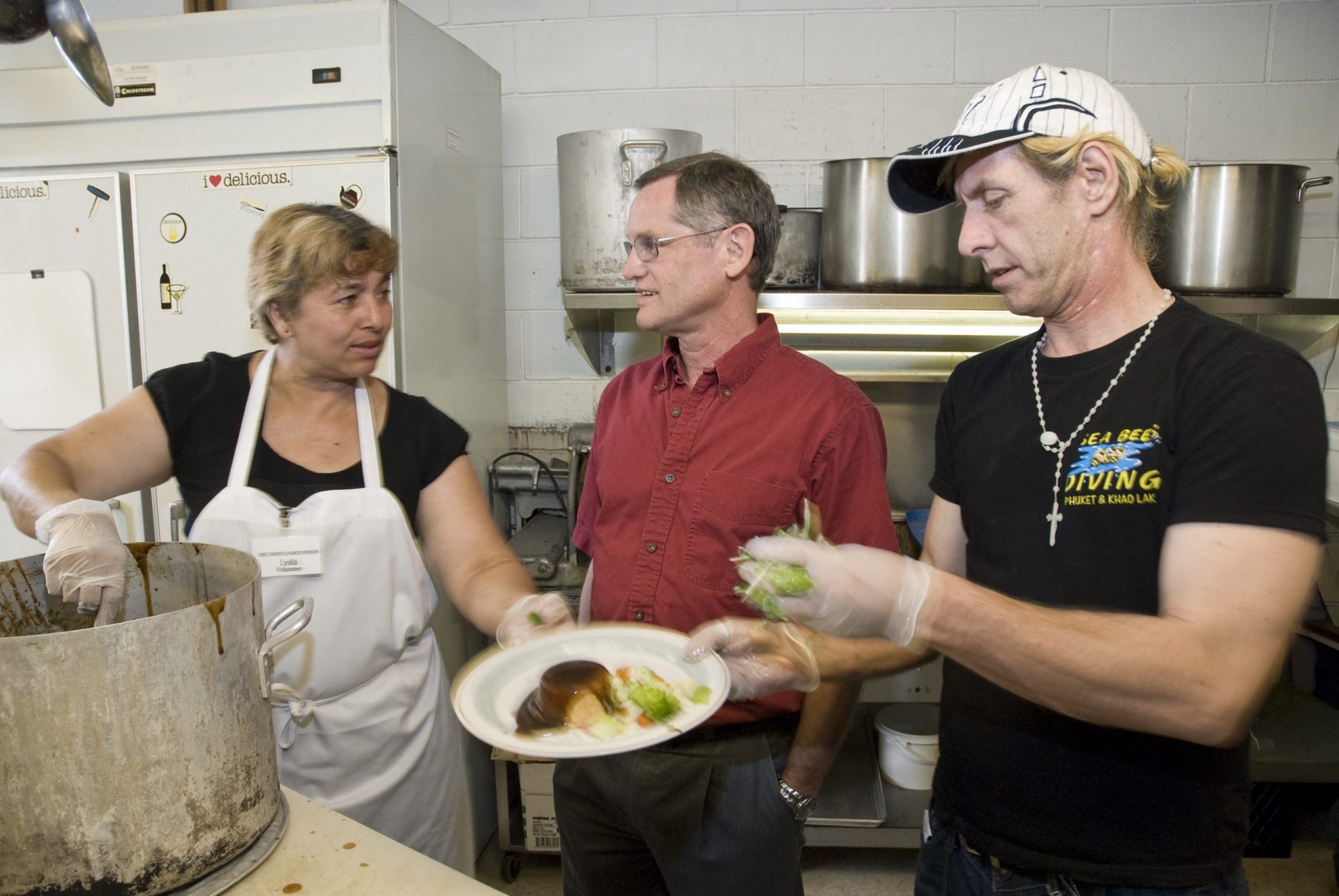 two white men and white woman in kitchen