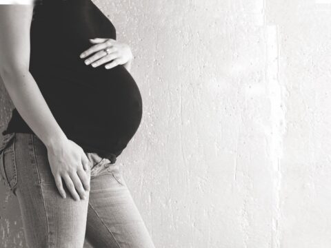 black and white photo of pregnant woman's torso