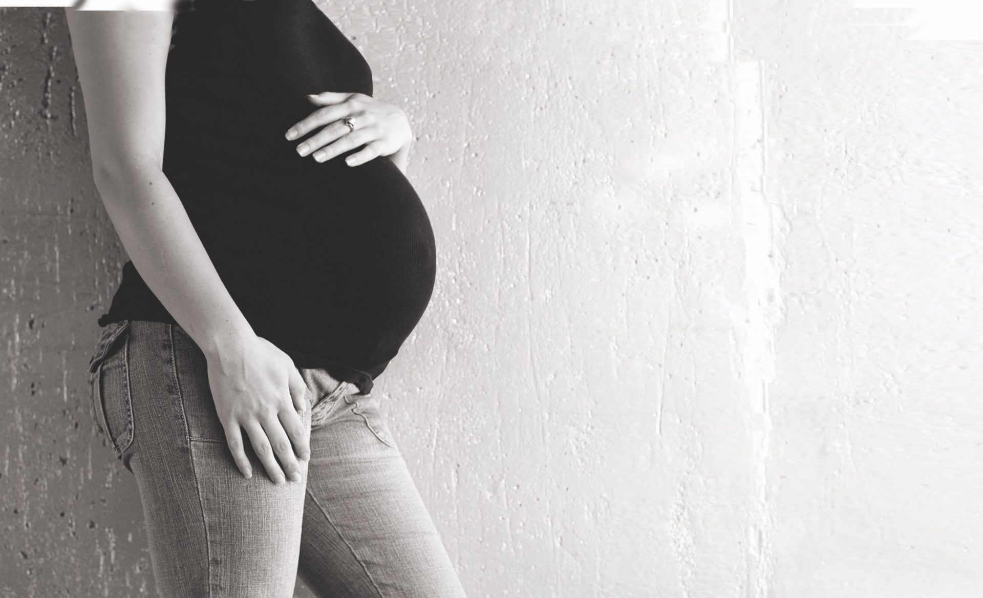 black and white photo of pregnant woman's torso