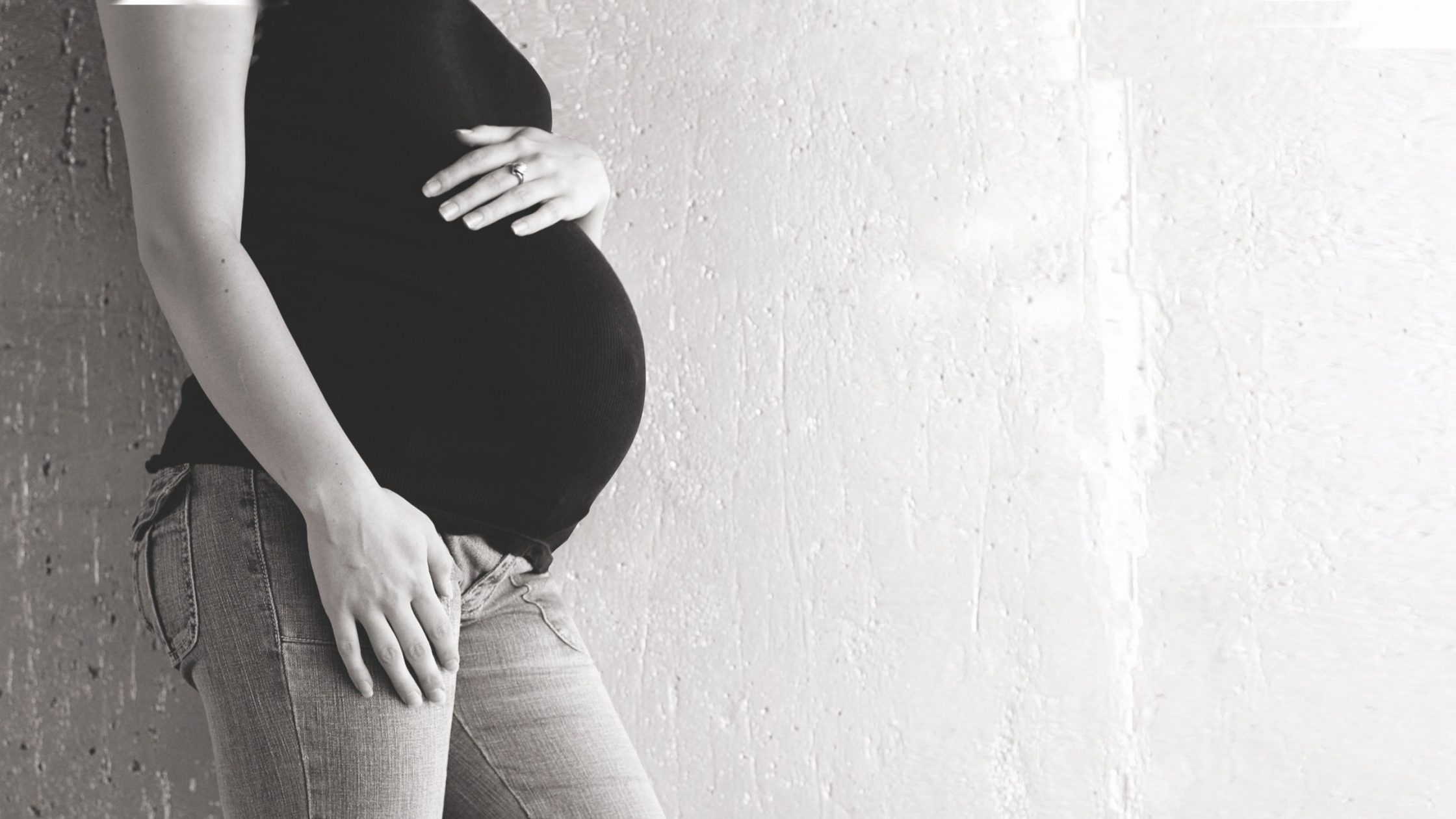 black and white photo of pregnant woman's torso