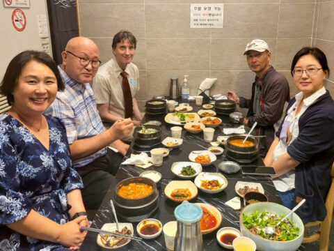 Five people sitting at a table having dinner