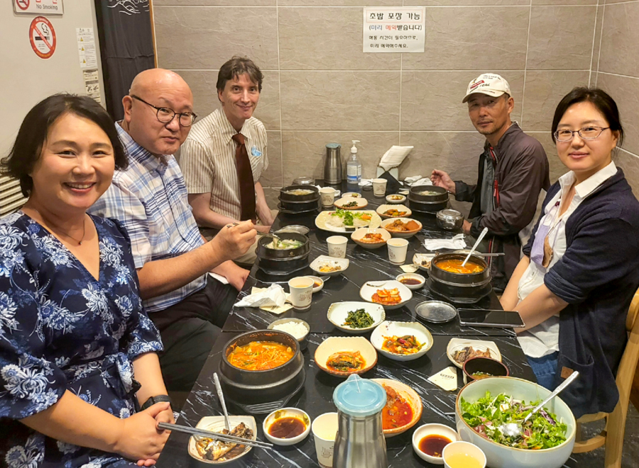 Five people sitting at a table having dinner