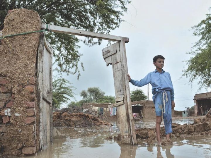 A boy stands in his partially damage home caused by flooding after heavy rains, in Jaffarabad, a district of Pakistan's southwestern Baluchistan province.