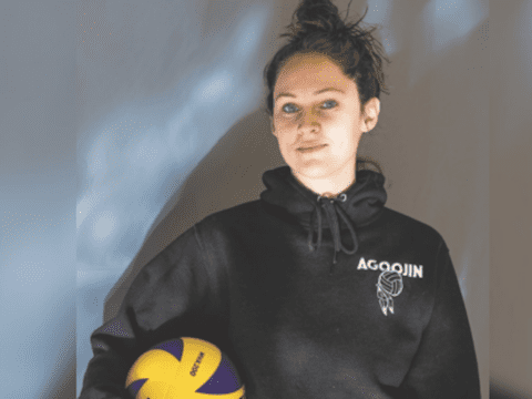 Jayme Menzies holding a volleyball.