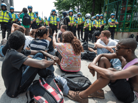 young people sit on street in protest in Montreal