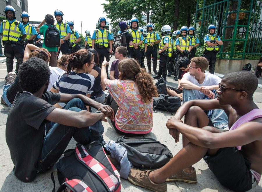 young people sit on street in protest in Montreal