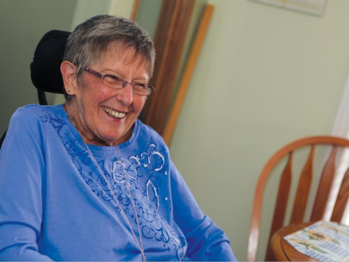 Elderly white woman in blue shirt, smiling
