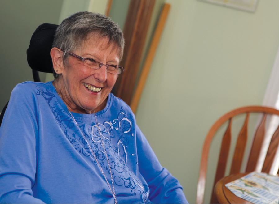 Elderly white woman in blue shirt, smiling
