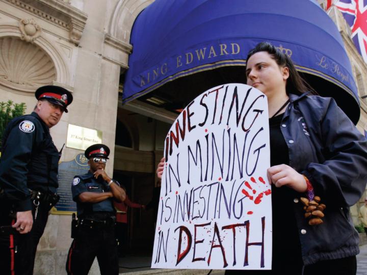 Young white woman protests with sign, police look on