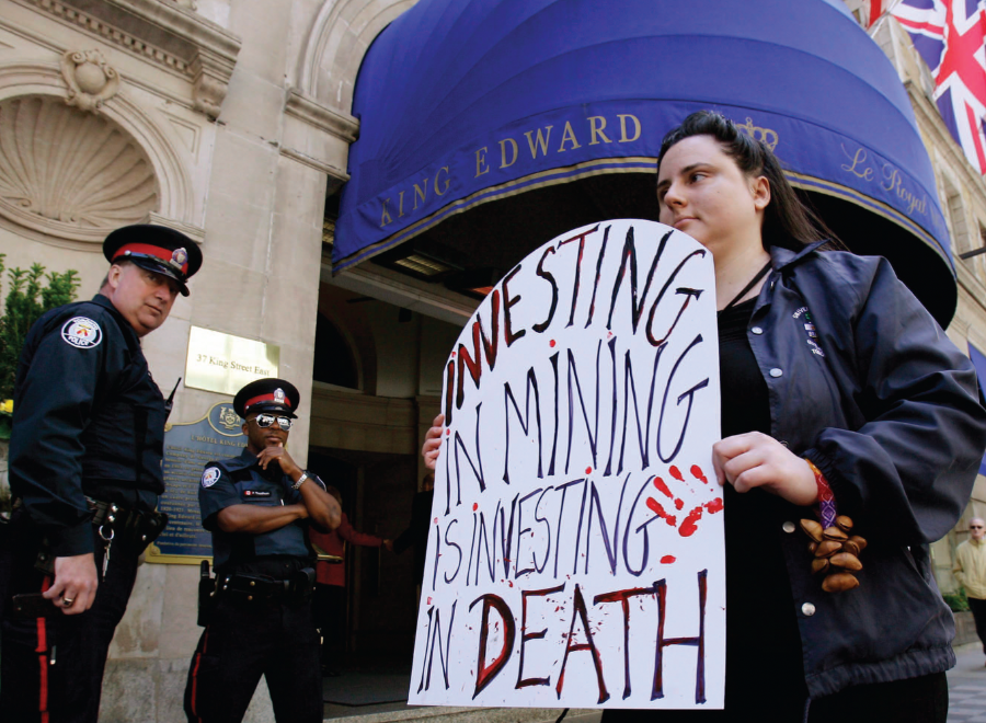 Young white woman protests with sign, police look on