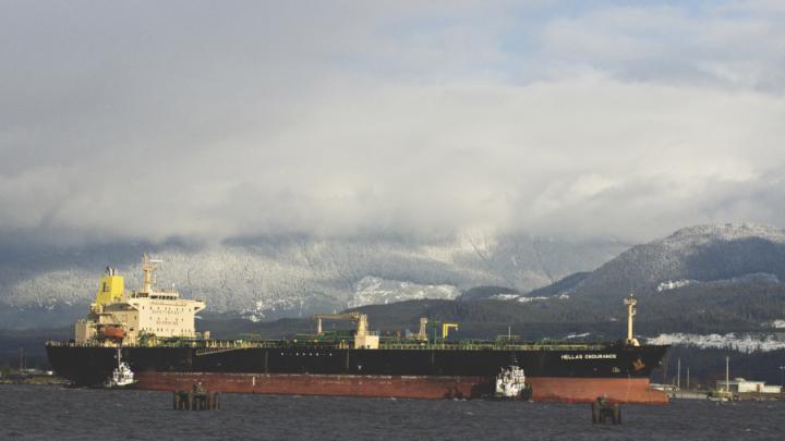 large ship in harbour against mountain backdrop