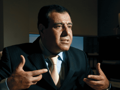 Man in dark suit, hands gesturing