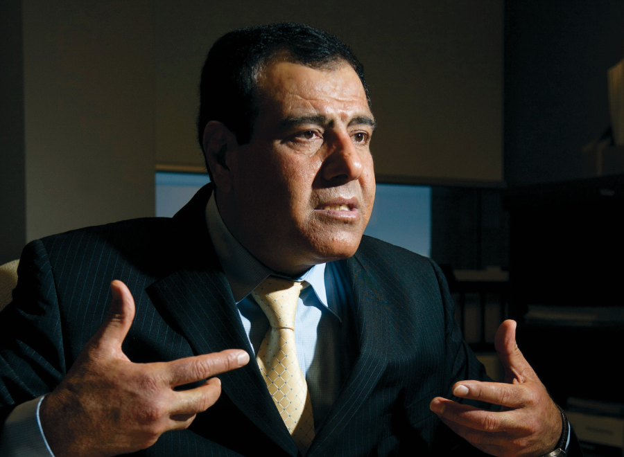 Man in dark suit, hands gesturing