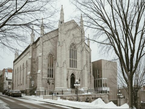 White church-like building with towering spires stands against a wintry landscape.