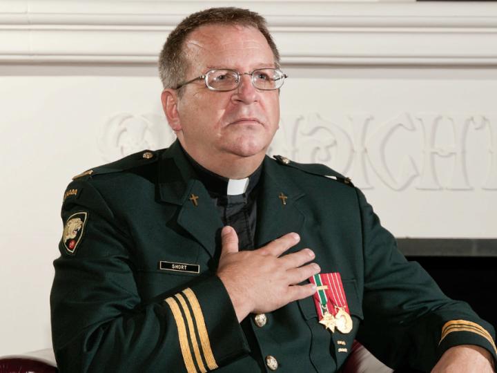 White male chaplain in military dress with hand on heart