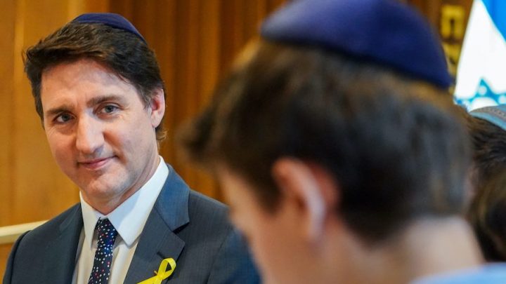 Prime Minister Justin Trudeau looks on as a child speaks while meeting with members of the Jewish community for Passover