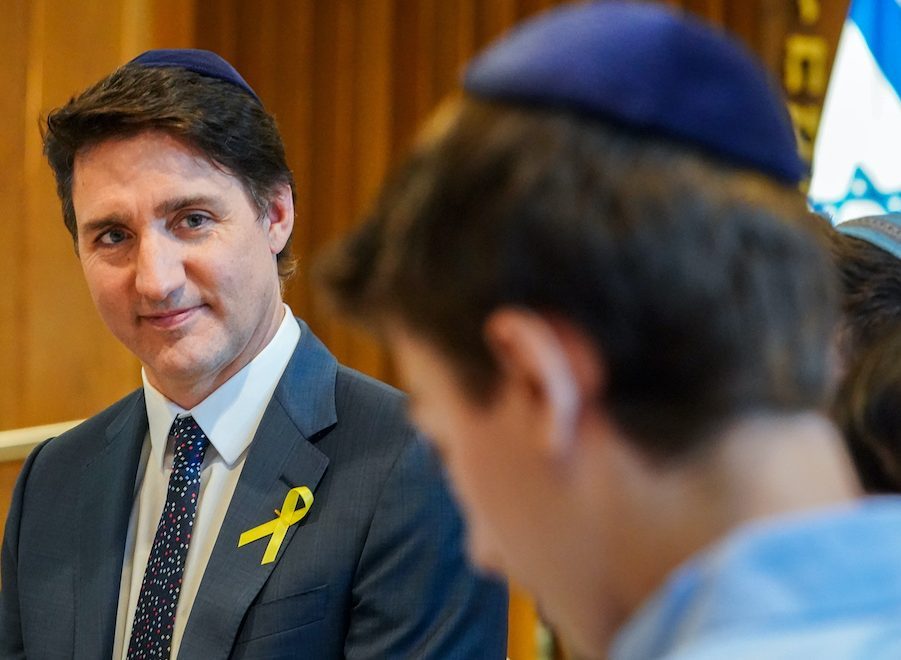 Prime Minister Justin Trudeau looks on as a child speaks while meeting with members of the Jewish community for Passover