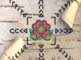 A Cree writing system on birch bark with a beaded red and green flower on top of it