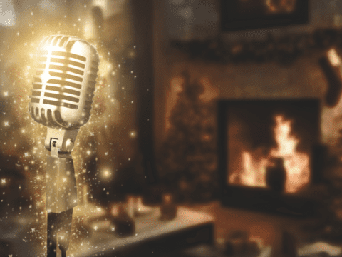 A sparkling microphone stands in the foreground and you can see a fireplace in the background