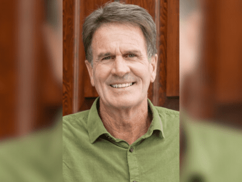 photo of smiling Caucasian man in a green collared shirt