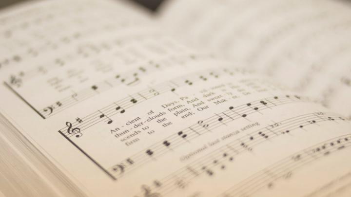 Close up of a hymn book showing musical notes and lyrics