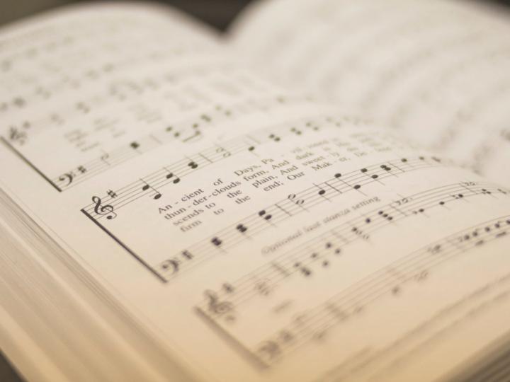 Close up of a hymn book showing musical notes and lyrics