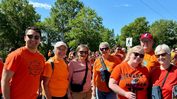 People pose for a photo wearing orange "Every Child Matters" shirts