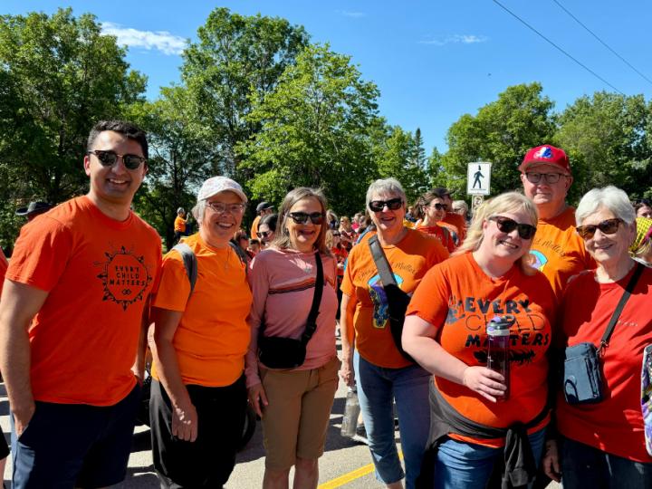 People pose for a photo wearing orange "Every Child Matters" shirts