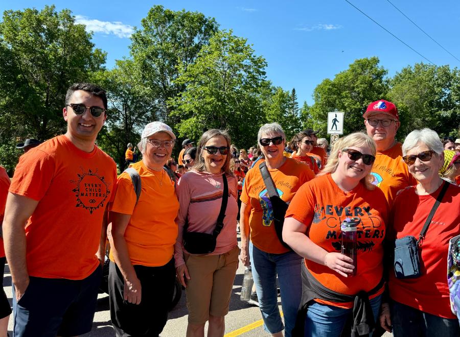 People pose for a photo wearing orange "Every Child Matters" shirts